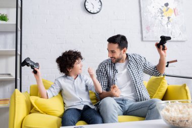 KYIV, UKRAINE - 15 Ocak 2021: joystick tutarken başarılı olan Arap baba ve oğlu