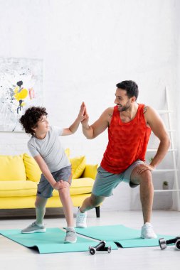 Olumlu Müslüman baba evde spor yaparken oğluna beşlik çakıyor. 
