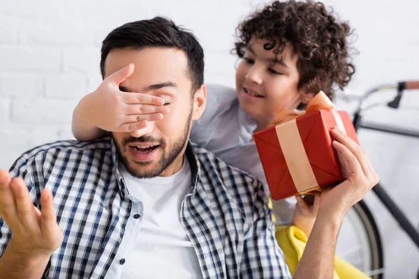 Muslim Boy Covering Eyes Father Holding Gift Box Blurred Background — Stock Photo, Image