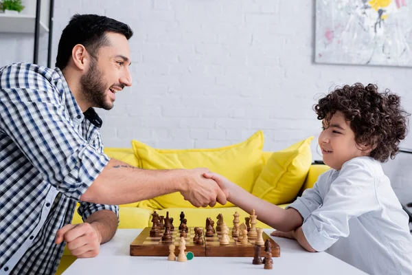 Χαμογελώντας Άραβας Πατέρας Και Παιδί Χειραψία Κοντά Στο Σκάκι — Φωτογραφία Αρχείου