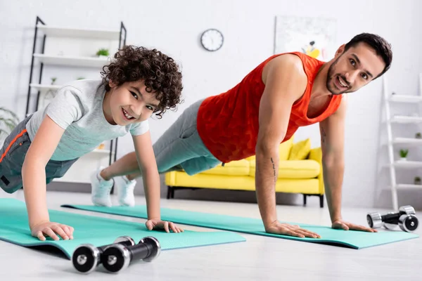 Smiling Arabian Boy Standing Plank Father Dumbbells Home — Stock Photo, Image