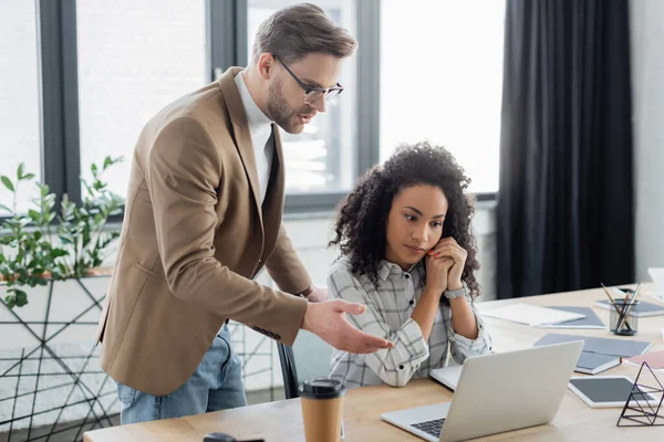 Geschäftsmann Zeigt Auf Laptop Neben Amerikanischem Amtskollegen — Stockfoto