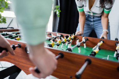 Masa futbolu oynayan çok kültürlü iş adamlarının görüntüsü bulanıklaştı