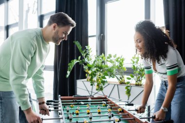 Ofiste masa futbolu oynayan mutlu çok kültürlü iş arkadaşları