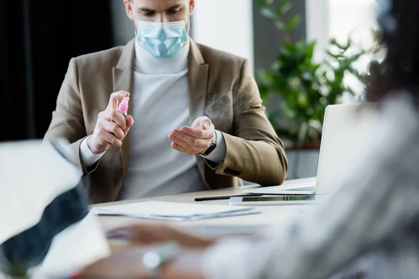 Hombre Negocios Máscara Médica Aplicando Desinfectante Manos Primer Plano Borroso — Foto de Stock