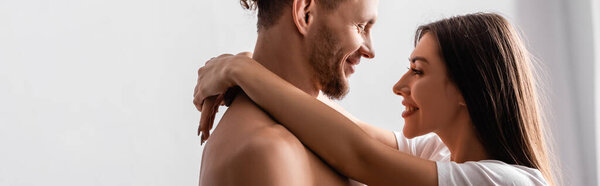 Вид сбоку улыбающейся женщины, обнимающей дерзкого бойфренда дома, баннер 