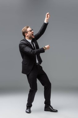 Gri renkli yumruklarını sıkmış kızgın iş adamının geniş görüşü