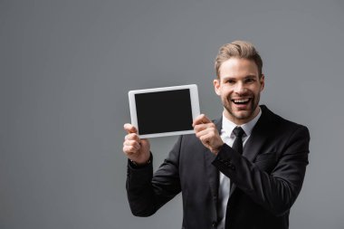 Gri ekranda boş ekranlı dijital tablet gösteren neşeli şirket yöneticisi