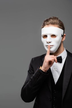 businessman in face mask showing hush sign isolated on grey clipart