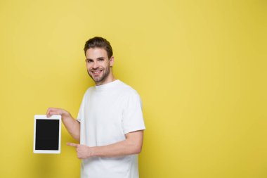 Sarı ekranlı dijital tableti gösteren memnun adam