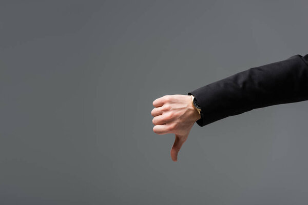 cropped view of businessman showing dislike isolated on grey with copy space