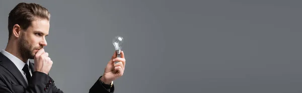 Homme Affaires Réfléchi Regardant Ampoule Isolée Sur Gris Bannière — Photo