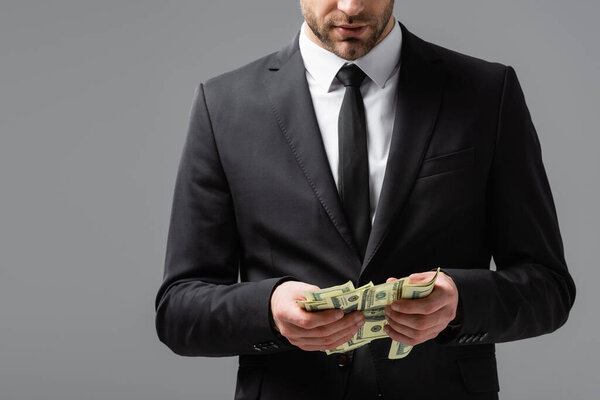частичный взгляд бизнесмена, подсчитывающего деньги, изолированные на сером