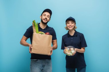 heyecan verici ırklar arası kuryeler kameraya gülümserken mavi paketleri ellerinde tutuyorlardı.