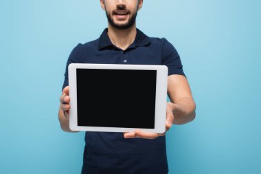 Mavi, bulanık arkaplanda boş ekranlı dijital tableti gösteren dağıtım elemanının kırpılmış görüntüsü