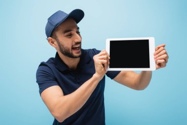 heyecan verici Arap kurye mavi üzerinde boş ekran ile dijital tablet gösteren