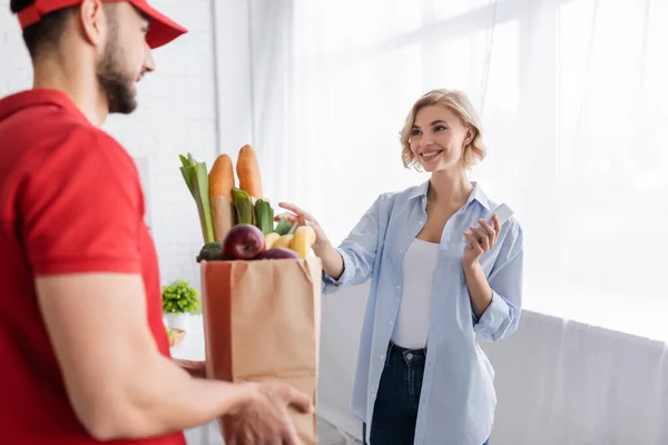 Blond Kvinna Tar Papperspåse Med Mat Från Arabiska Kurir Suddig — Stockfoto