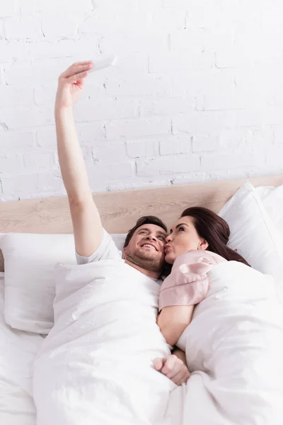 Sorrindo Homem Tomando Selfie Com Esposa Cama — Fotografia de Stock