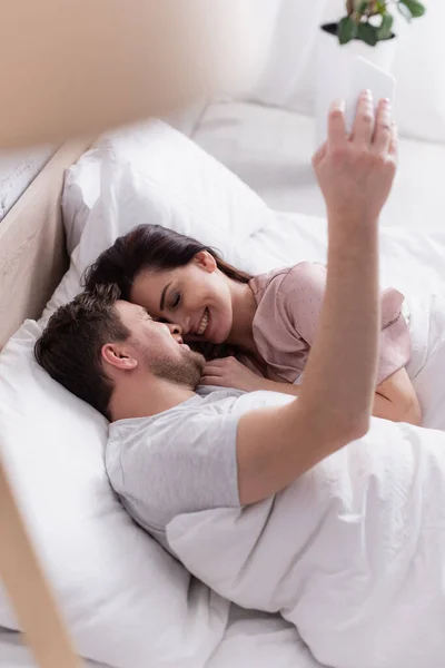 Sorrindo Casal Tomando Selfie Smartphone Cama — Fotografia de Stock