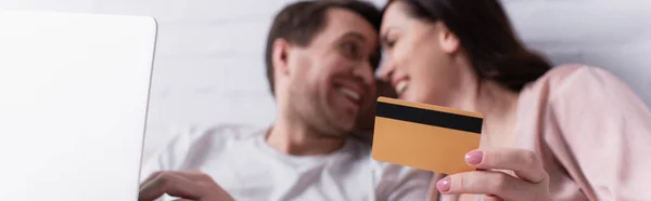 Credit Card Hand Woman Smiling Husband Laptop Blurred Background Banner — Stock Photo, Image