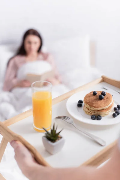 Hombre Sosteniendo Bandeja Con Panqueques Jugo Naranja Cerca Esposa Sobre —  Fotos de Stock