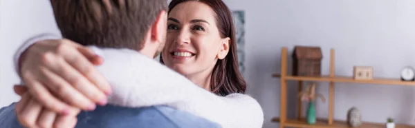 Gülümseyen Kadın Kocasını Kucaklıyor Bulanık Planda Pankartta — Stok fotoğraf