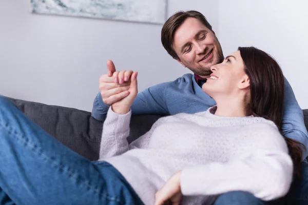 Sonriente Hombre Mirando Esposa Mientras Toma Mano Sofá — Foto de Stock