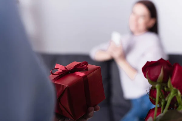 Present Red Flowers Hand Man Standing Wife Blurred Background — Stock Photo, Image