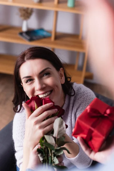 Щаслива Жінка Тримає Квіти Біля Чоловіка Подарунком Розмитому Фоні — стокове фото