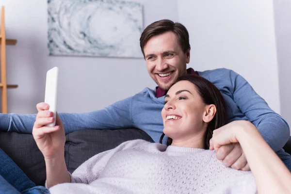 Smiling Adult Couple Using Smartphone Couch — Stock Photo, Image