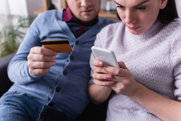 Mulher Usando Celular Perto Marido Com Cartão Crédito Casa — Fotografia de Stock