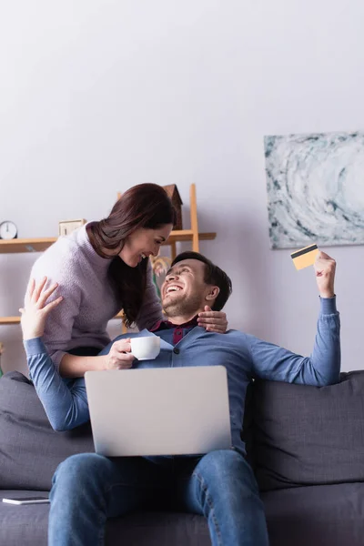 Vrolijk Paar Met Beker Creditcard Zoek Naar Elkaar Buurt Laptop — Stockfoto