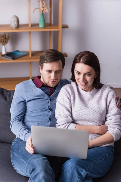 Man Looking Laptop Cheerful Wife Couch Living Room — Stock Photo, Image