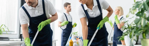 Reinigungskräfte Mit Mops Der Nähe Von Kollegen Auf Verschwommenem Hintergrund — Stockfoto