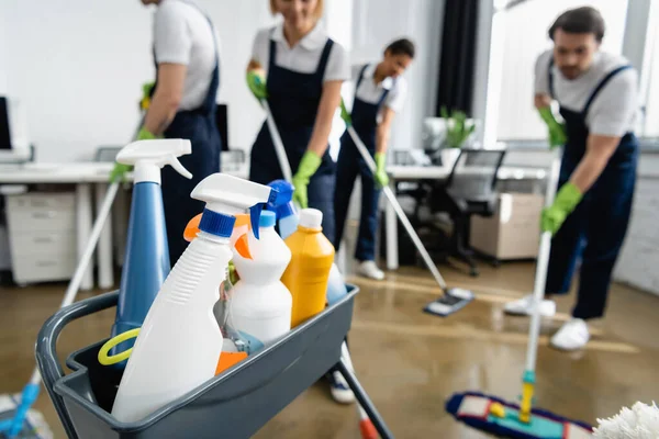 Bottiglie Con Detergenti Vicino Detergenti Che Lavorano Sfondo Sfocato Ufficio — Foto Stock