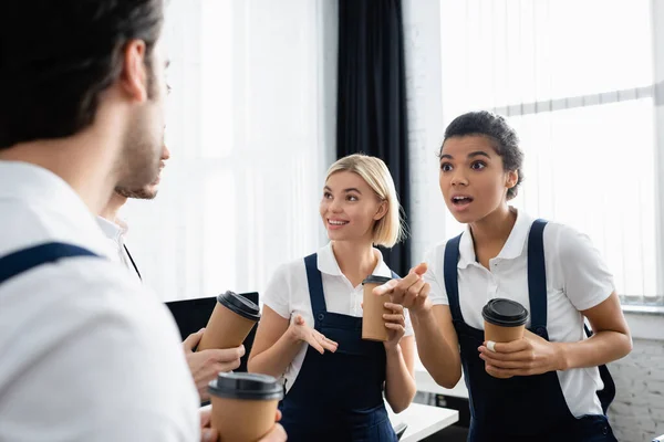 Excited African American Cleaner Takeaway Drink Pointing Colleague Blurred Foreground — Stock Photo, Image