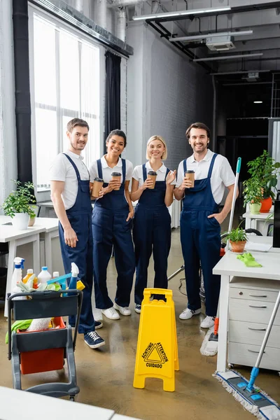 Cheerful Multiethnic Cleaners Holding Coffee Detergents Office — Stock Photo, Image