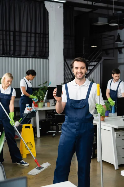 Leende Arbetare Städföretag Som Håller Smartphone Med Blank Skärm Kontoret — Stockfoto