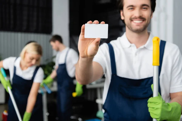 Tarjeta Vacía Mano Limpiador Sonriente Con Fregona Sobre Fondo Borroso — Foto de Stock