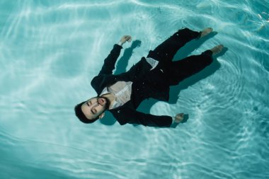 Top view of arabian man in suit lying in swimming suit  clipart
