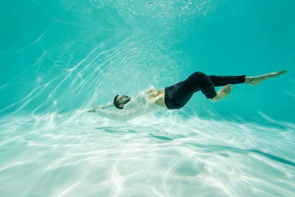 Arabian Człowiek Białej Koszuli Pływanie Pod Wodą Basenie — Zdjęcie stockowe