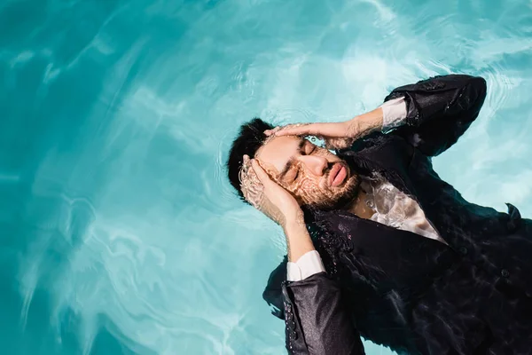 プールで泳いでいる頭の近くに手を持つアラビア人のビジネスマンのトップビュー — ストック写真