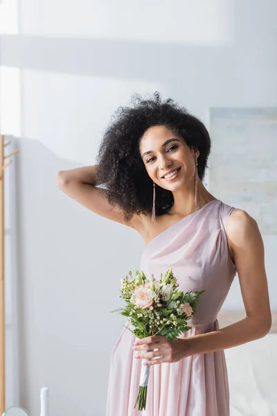 Charming African American Bridesmaid Touching Hair While Holding Wedding Bouquet — Stock Photo, Image