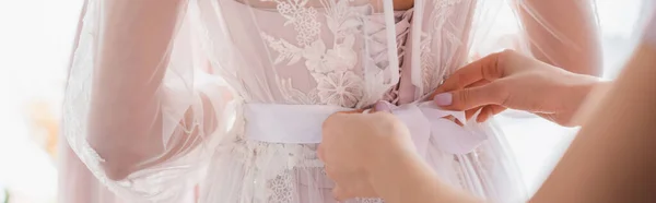 花嫁のレースドレスにリボンを結ぶ女性のクロップドビュー ぼやけた前景 バナー — ストック写真