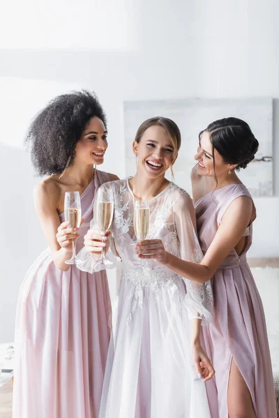 笑容满面的新娘在卧室里 在欢乐的跨种族朋友面前举着香槟 — 图库照片