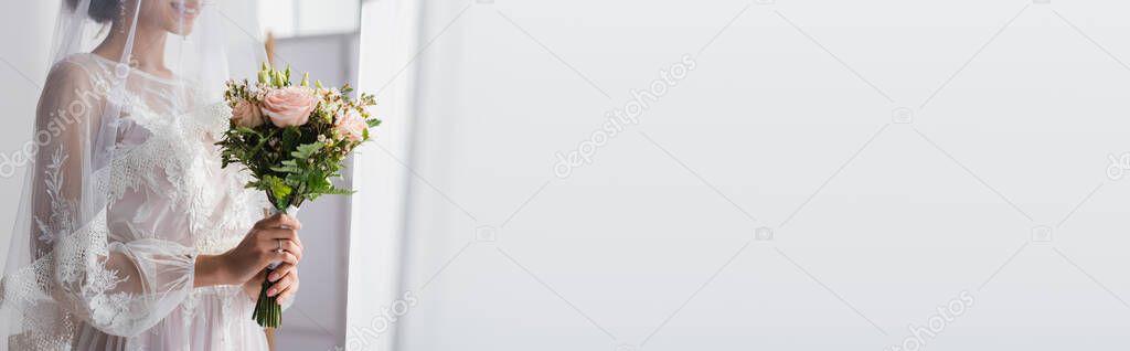 partial view of happy african american bride with wedding bouquet, banner