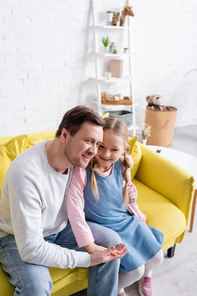 Feliz Hombre Abrazando Hija Mientras Está Sentado Sofá Casa — Foto de Stock