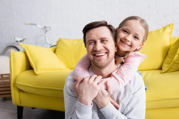 Adult Man Laughing While Cheerful Daughter Hugging Him Home — Stock Photo, Image