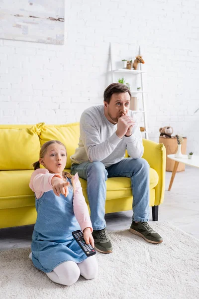 Menina Surpreendida Apontando Com Dedo Enquanto Assiste Filme Com Pai — Fotografia de Stock