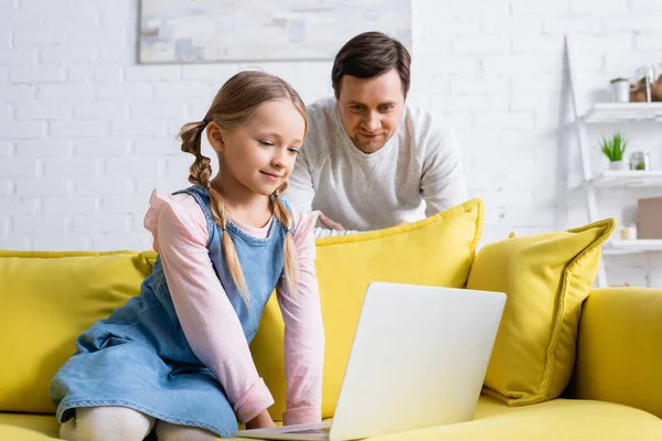 Lächelndes Mädchen Schaut Film Auf Laptop Neben Lächelndem Vater — Stockfoto